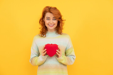 happy redhead woman with red heart on yellow background. love