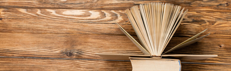 top view of books on wooden textured desk, banner.