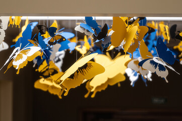 ceiling decorated with decorative colored paper butterflies, selective focus, blurred background