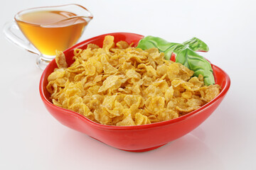 Breakfast milk into corn flakes creating splash apple and orange fruit  honey