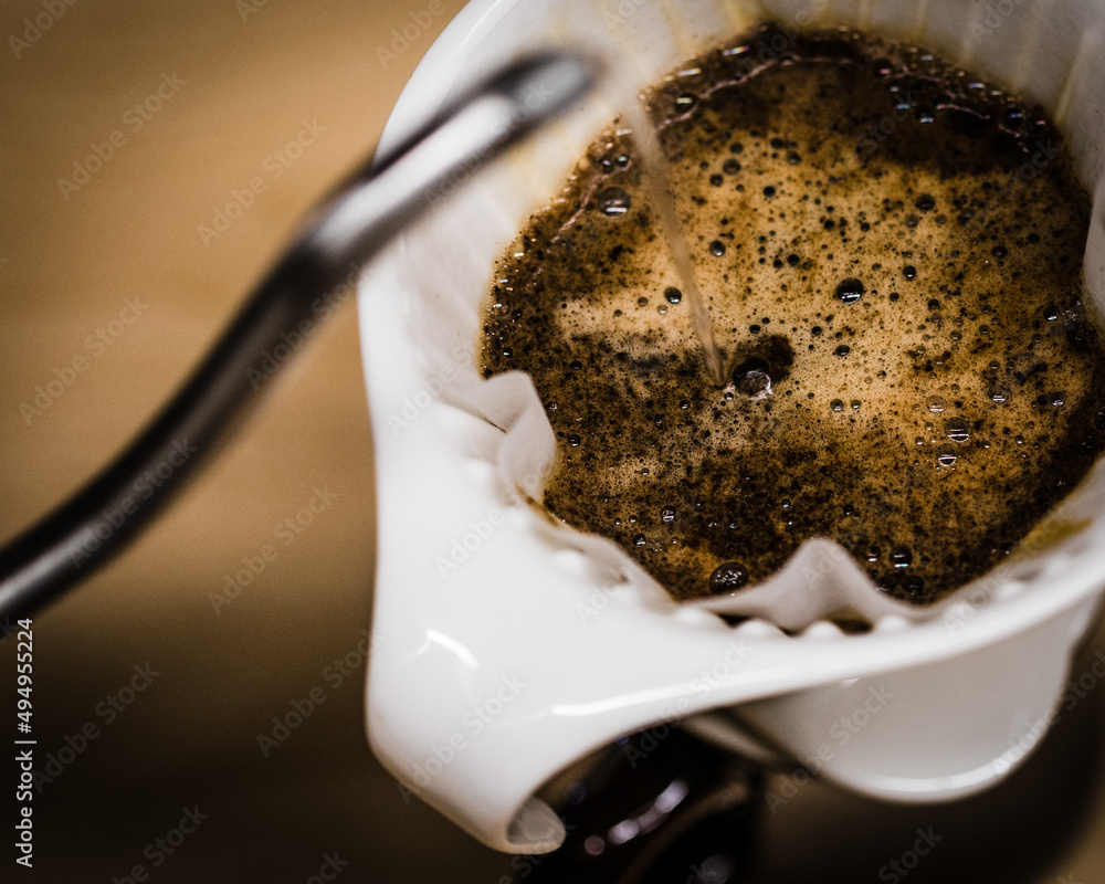 Poster Closeup shot of the pour over coffee brewer on the brown background