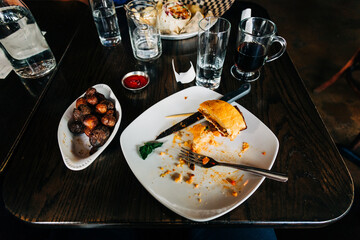 Top view of an unfinished meal on a wooden table at a restaurant