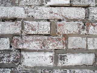 Old weathered brick wall with white patina close-up. Background for design.