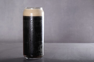 Staut. Dark filtered beer in a glass glass stands on a gray background. Gray background, there is a...