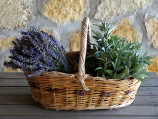 A bunch of sage and a bunch of lavender on a willow basket.  