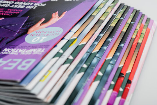 close up view of colorful magazines collection isolated on grey.