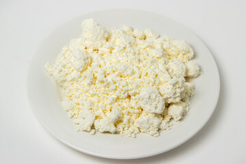 A plate of cottage cheese on a white background. Healthy and tasty dairy product.
