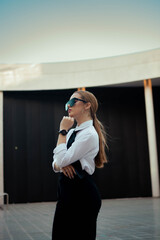 Blonde businesswoman with ponytail sunglasses and a classy outfit