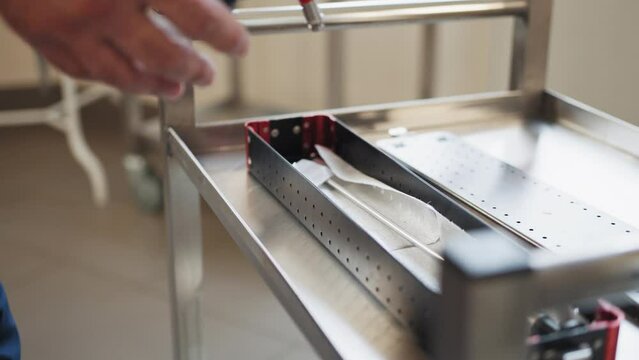 Surgical instrument. Close up of man pulling laparoscopic instrument out of box. Preparation for laparoscopy. Preparation for surgery. Close laparoscopic tools. Using laparoscopic equipment.