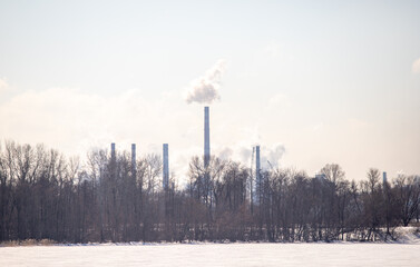 Ecological landscape, pipes of the plant smoke on the background of nature.