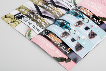 top view of several beauty magazines on grey background.