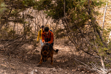 Hiking in the forest with their dog together while having a fun time