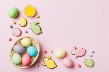 Colorful easter cookies in basket with Multi colors Easter eggs on colored background . Pastel color Easter eggs. holiday concept with copy space