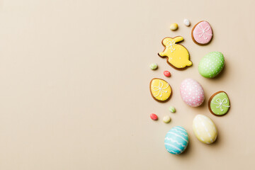 Obraz na płótnie Canvas holiday preparation Multi colors Easter eggs with cookies on colored background . Pastel color Easter eggs. holiday concept with copy space