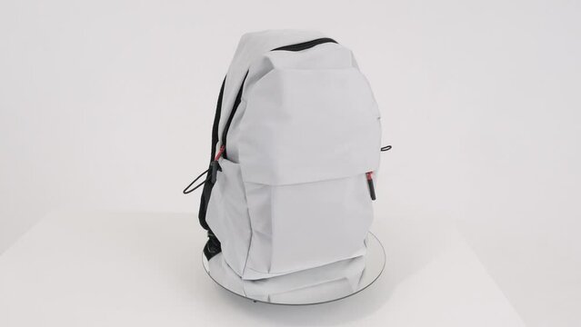 Closeup gray backpack bag rotates on white background, 4K