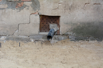 Rainwater pipe. Rain water draining gutter pipe of a house. Plastic drain pipeline on the wall of a building. Architecture, weather concept.