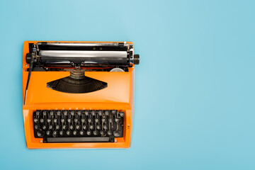 top view of vintage typing machine isolated on blue.