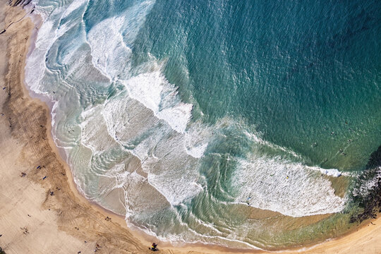 Aerial view of the wavy sea hitting the sandy Maroubra beach on the coast