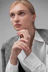 Elegant girl posing in a plaid suit