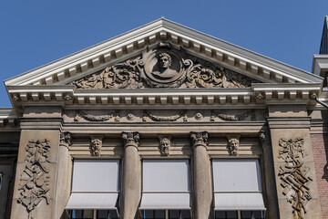 Architectural fragments of Barlaeus Gymnasium (established in 1884 - 1885) building in neo-classicism and eclecticism style. Amsterdam, the Netherlands.