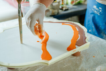 Female artist creating clock in resin art technique