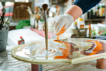 Female artist creating clock in resin art technique