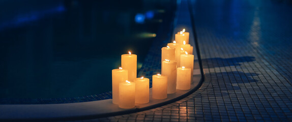 Relaxing spa background with candles near the pool in the evening