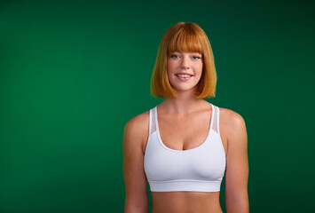 Fototapeta na wymiar Commit to be fit. Cropped portrait of an attractive young sportswoman standing alone against a green background in the studio.