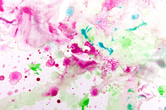 paints on a white sheet of paper. drops of pink, green, turquoise color. background and texture of watercolor paints. © tumskaia