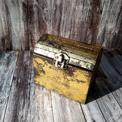 small decorative chest for jewelry on a wooden background. the concept of savings and searching for old lost treasures