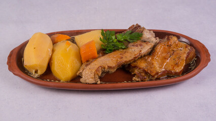 View of steak cooked with vegetables on a brown plate isolated on a white background