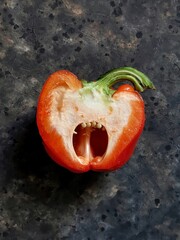 slice of red sweet pepper that screams with copy space on black concrete background