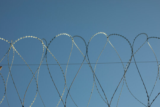Barbed wire on fence. Fencing of industrial zone. Safety from thieves.