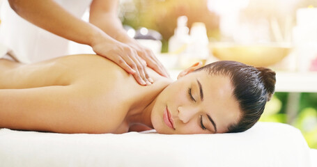 Your back pain will disappear just like magic. Shot of a young woman getting a back massage at a spa.