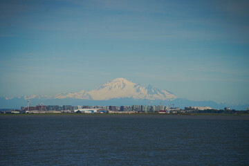 Scenic shot of the city situated in front of the sowy mountain and on the shore of the sea © Chelaxy/Wirestock Creators