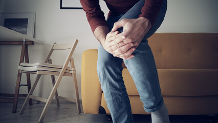 Man with injured knee at home.