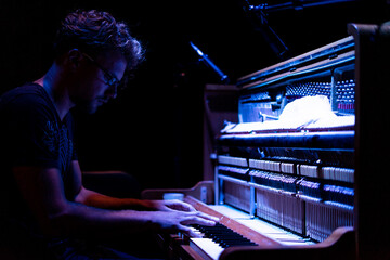 Male pianist playing on an old wooden piano