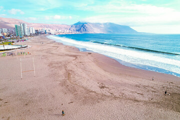 Landscape of a beach surrounded by the sea and buildings in Iquique, Chile