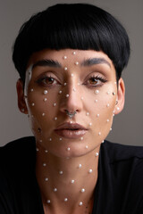 Pearls are always appropriate. Studio portrait of a beautiful young woman with pearls on her face...