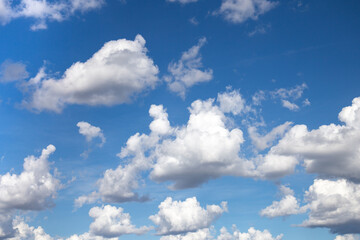 Naklejka na ściany i meble White cotton-textured clouds on a blue sky background 