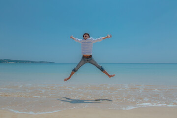 Obraz premium 波打ち際でジャンプする男性