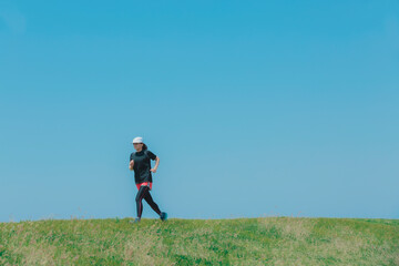 草原をランニングする女性