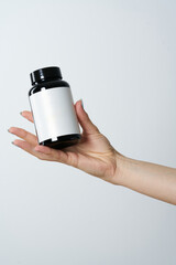 woman hand hold drag or medicine bottle on white background - 494991011