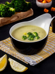 Healthy broccoli green peas cream soup in bowl on dark background. Diet detox food concept. Turkish...