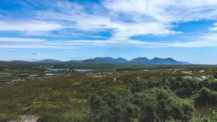 Beautiful landscape of the Connemara region of Ireland with mountains in the distance blue sky