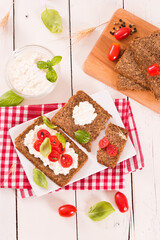 Rye bread with cottage cheese, basil and tomato.
