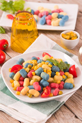 Colored gnocchi with vegetables and sweet corn.