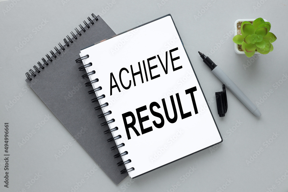 Aufkleber achieve result two notebooks on a gray background. text on notebook -