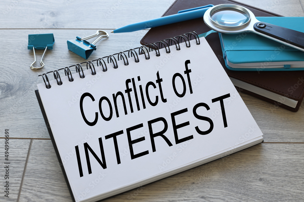Aufkleber conflict of interests text on open notepad