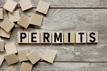 permits text on wooden cubes on wooden background